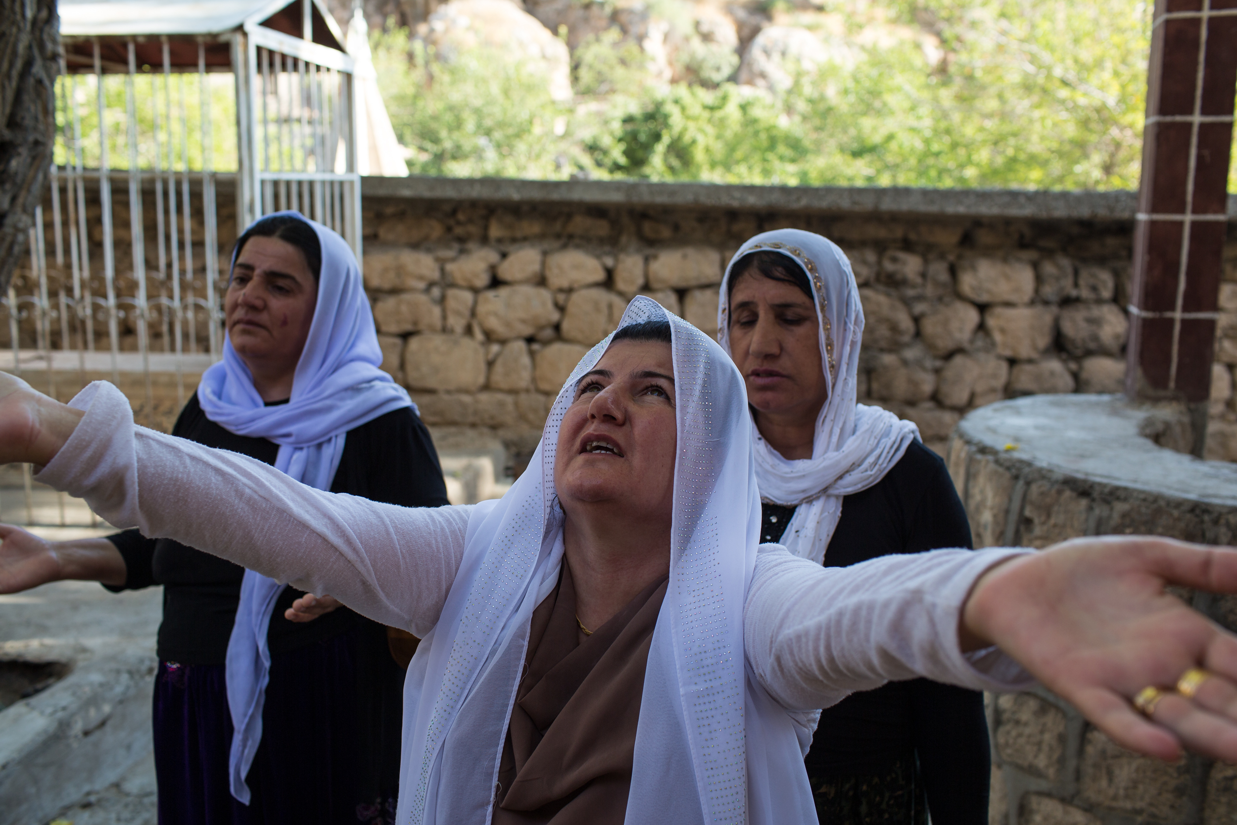 A Yezidi woman prays on the sacred grounds of Lalish.