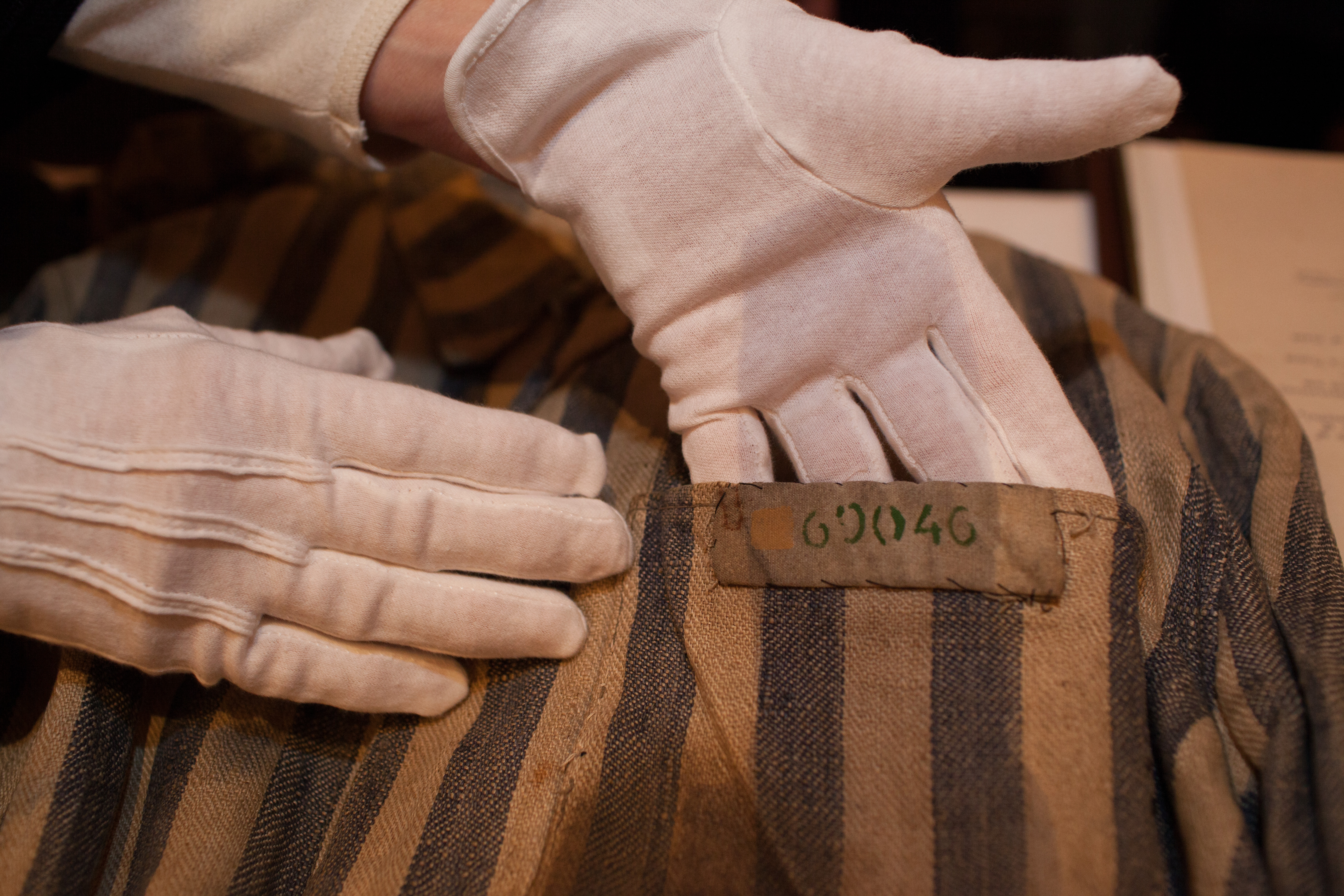 U.S. Holocaust Memorial Museum textile conservator carefully handles a concentration camp uniform, March 2013.