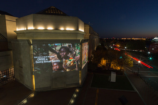 A picture of the crisis in the Central African Republic, featuring a young girl, is projected on the exterior of the Museum