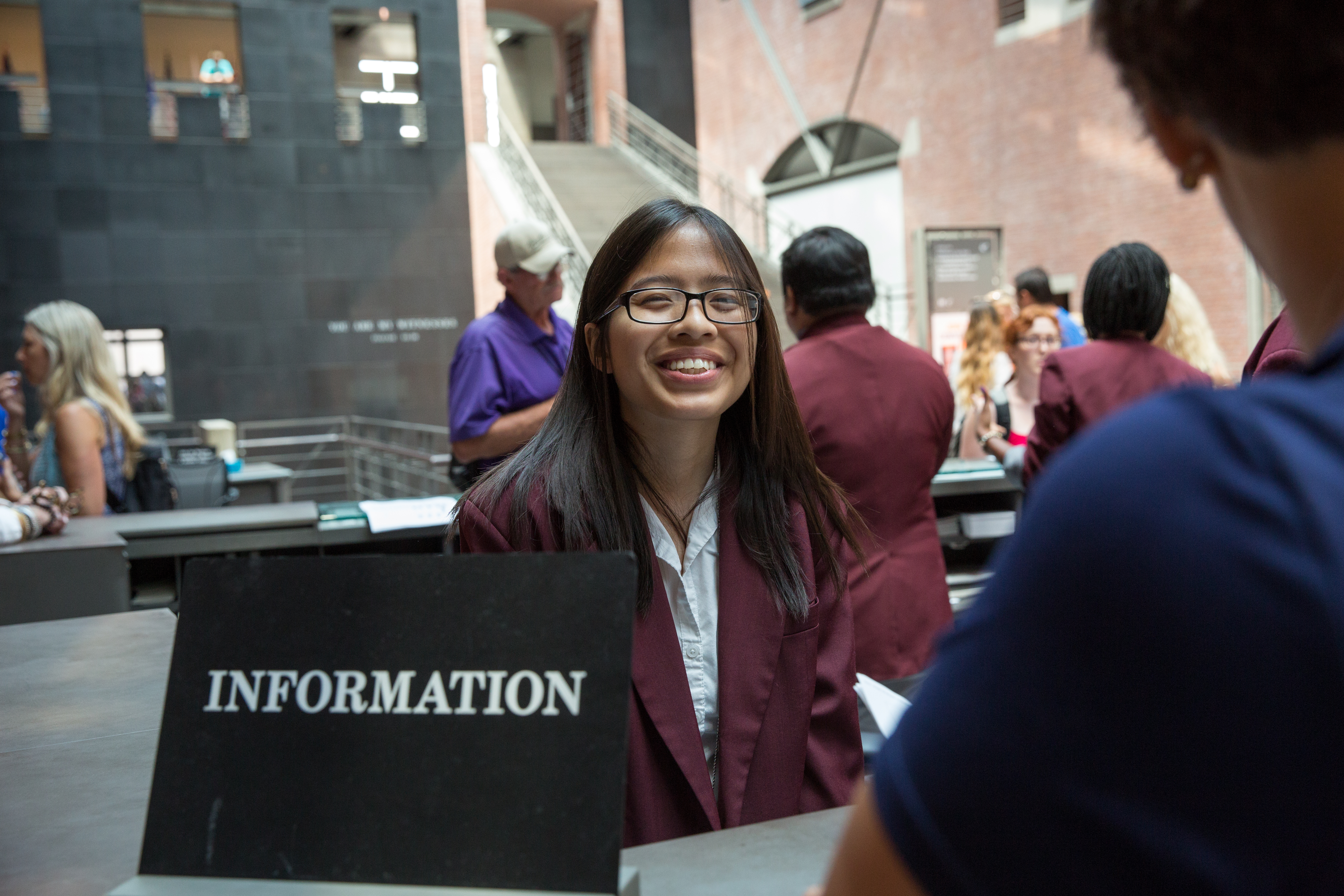 A museum volunteer stands at the Information Desk