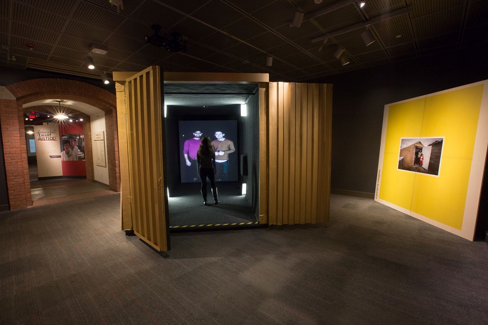 A visitor in the Portal at the United States Holocaust Memorial Museum speaks with Omar and a friend in Berlin’s Tempelhof airport, which provides services to refugees.