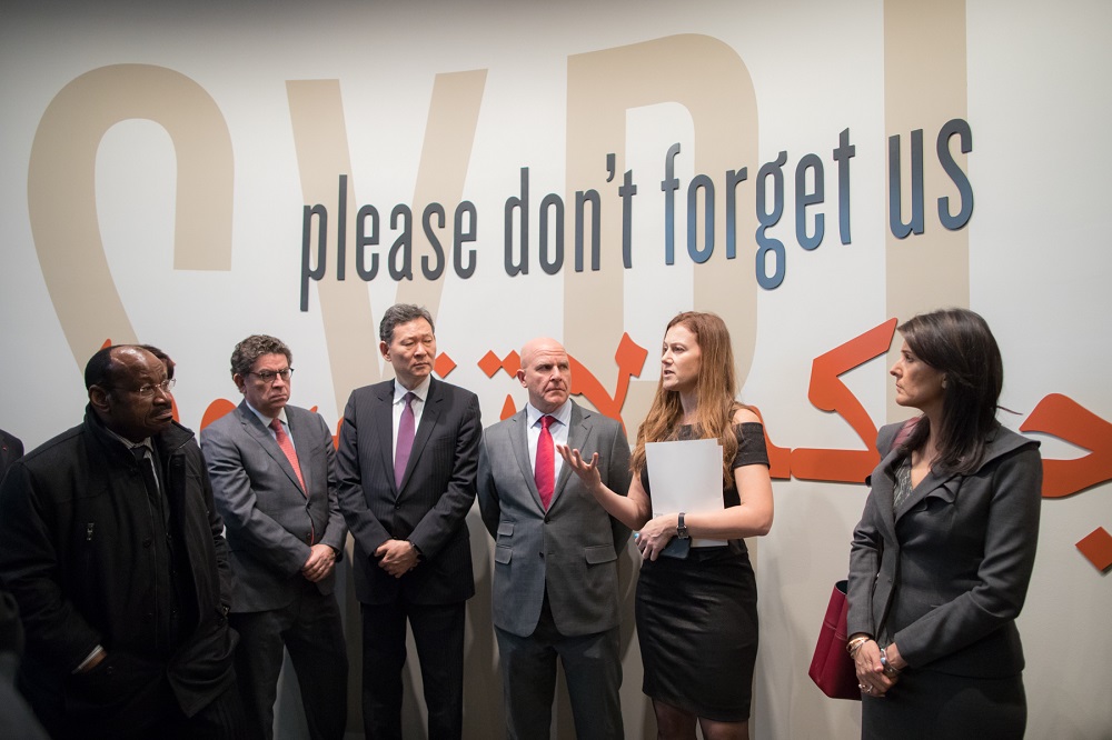 Simon-Skjodt Center Deputy Director Naomi Kikoler tours the UNSC delegation through the Syria exhibition.