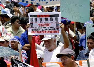 A man lifts a poster demanding justice for genocide.