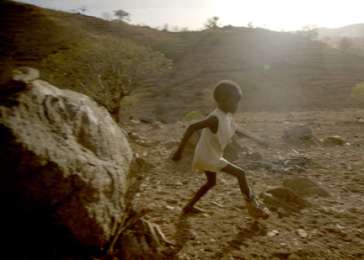 Six-year-old Kuti plays by his grandmother’s hut in Sudan’s Nuba Mountains.