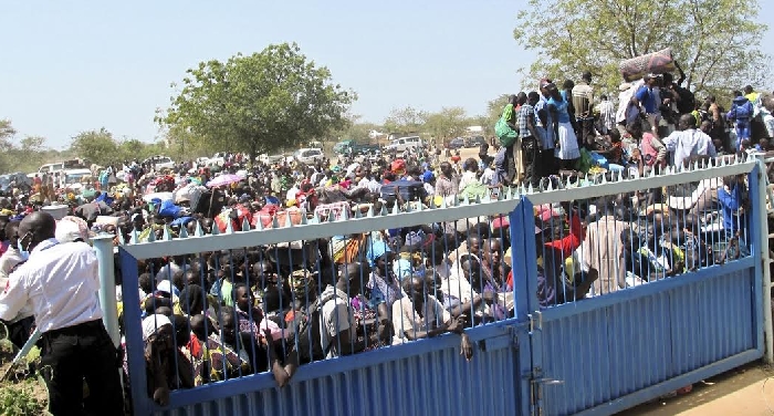 Civilians seeking refuge from the fighting wait outside a compound of the UN mission in South Sudan, December 18, 2013.