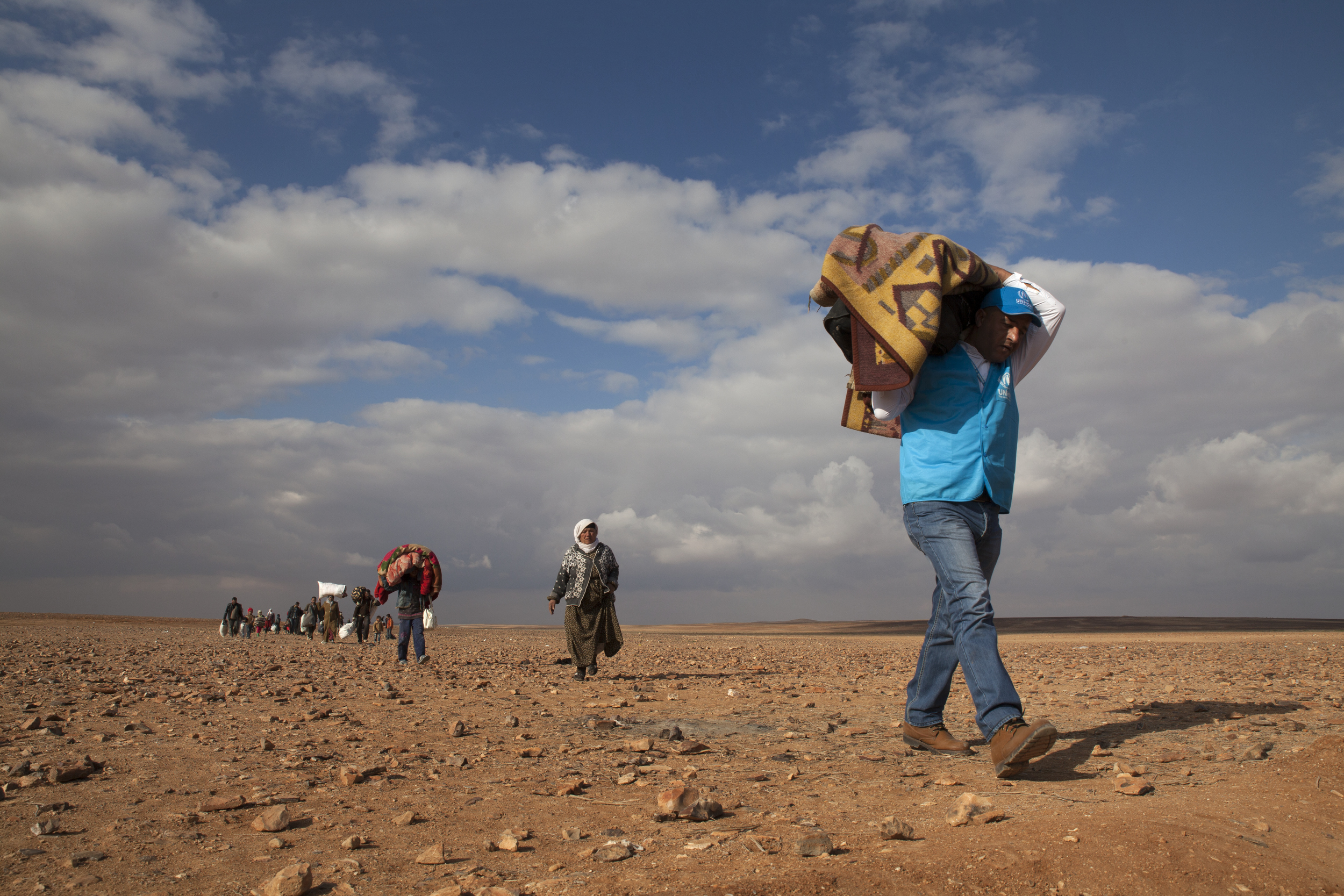 Members of the UN High Commissioner for Refugees assist civilians fleeing violence in Syria, February 2014. 


