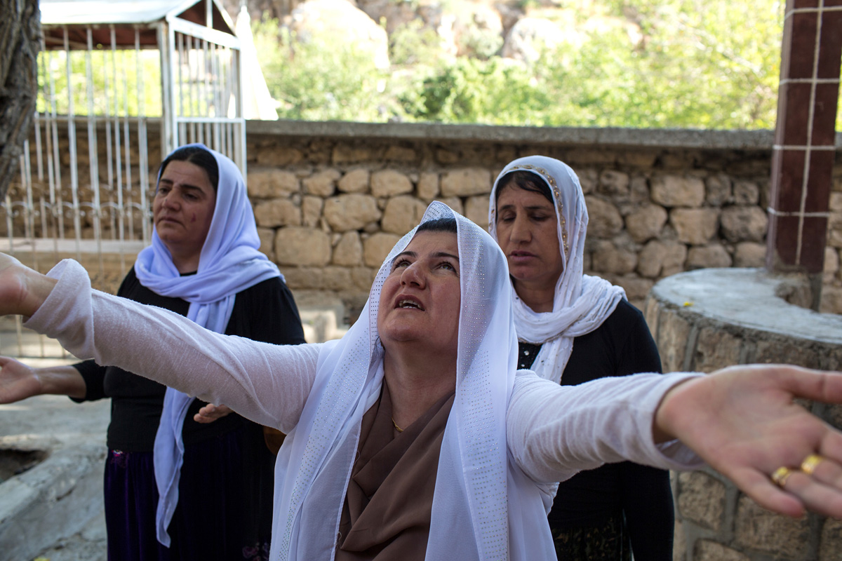 A Yezidi woman prays on the sacred grounds of Lalish.