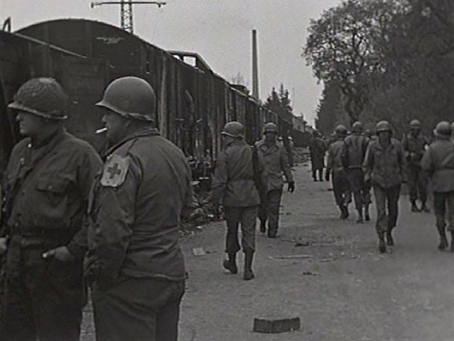 Uniformed men standing in front of train cars