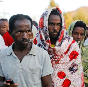 Men stand in line to receive food donations, at the Tsehaye primary school, which was turned into a temporary shelter for people displaced by conflict, in the town of Shire, Tigray region, Ethiopia, March 15, 2021.