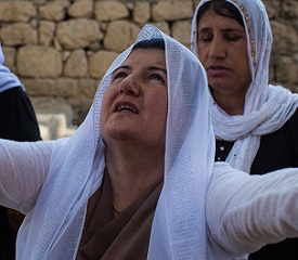 A Yezidi woman prays on the sacred grounds of Lalish.