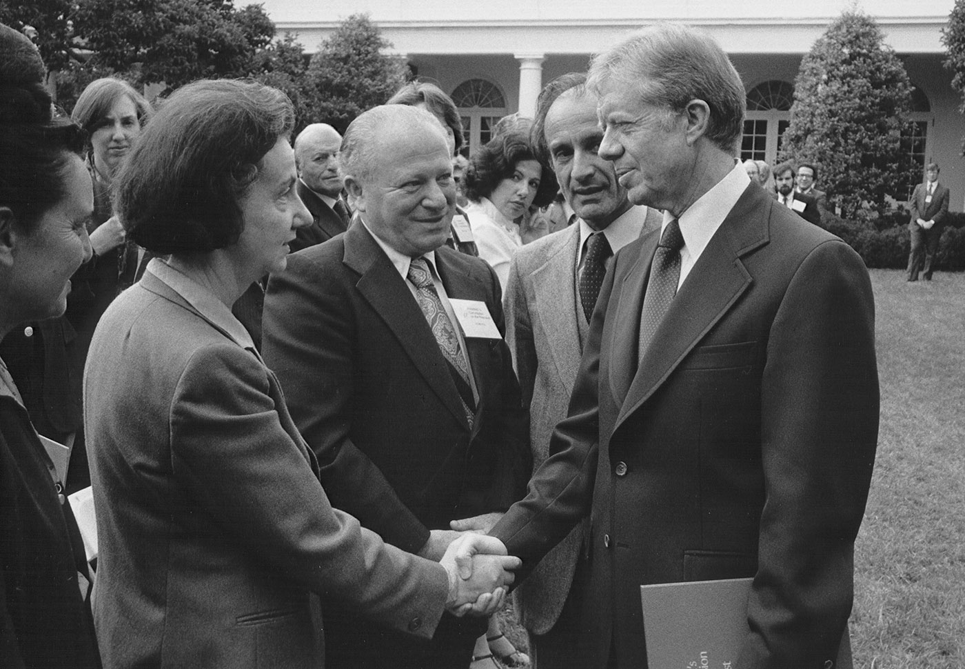 President Jimmy Carter shakes the hand of Vladka Meed during a ceremony in the White House Rose Garden, during which Elie Wiesel presented the report of the US Holocaust Commission.