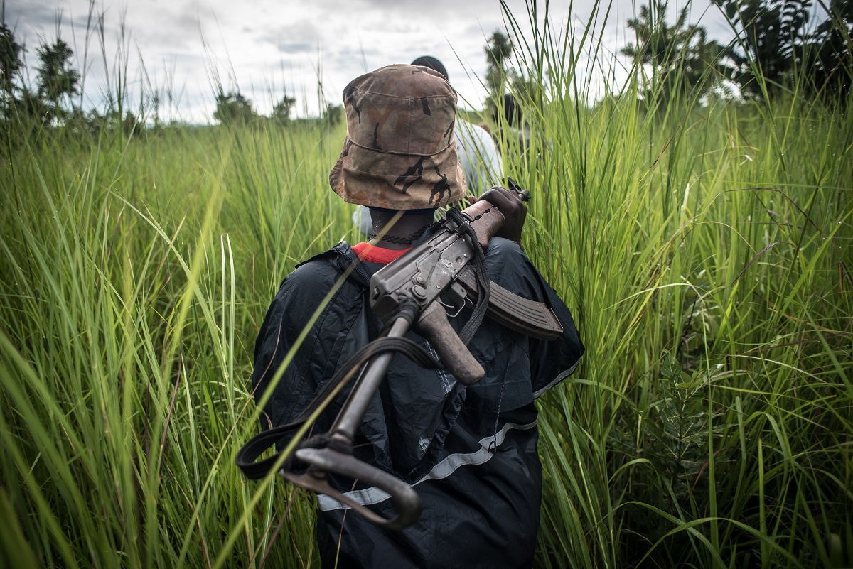 A SPLA-In Opposition soldier walks with her weapon through the elephant grass in rebel-held Magwi county of South Sudan’s Eastern Equatoria state on August 28, 2017.