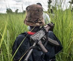 A SPLA-In Opposition soldier walks with her weapon through the elephant grass in rebel-held Magwi county of South Sudan’s Eastern Equatoria state on August 28, 2017.