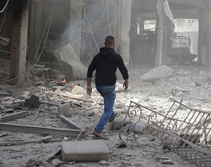 A man walks on rubble at a damaged site after an air strike on February 9, 2018, in the besieged town of Douma in the Eastern Ghouta area of Damascus, Syria.