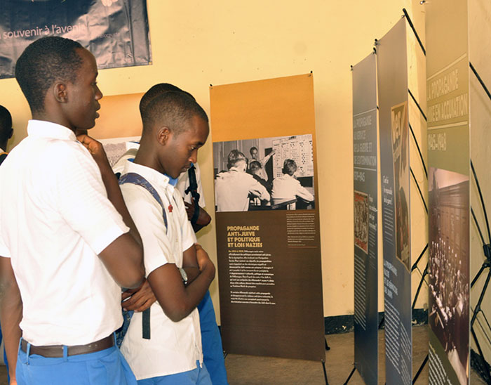 Los estudiantes visitan una exposición de carteles de Estado de engaño en Buyumbura, Burundi.