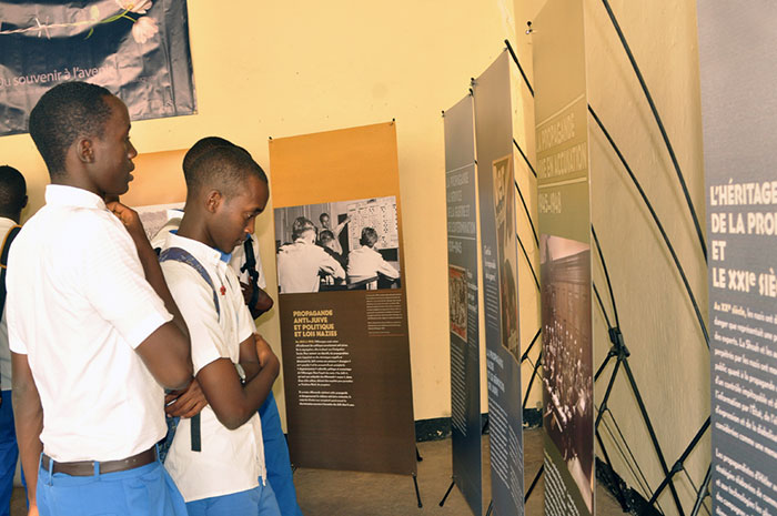 Students visit a State of Deception poster exhibition.