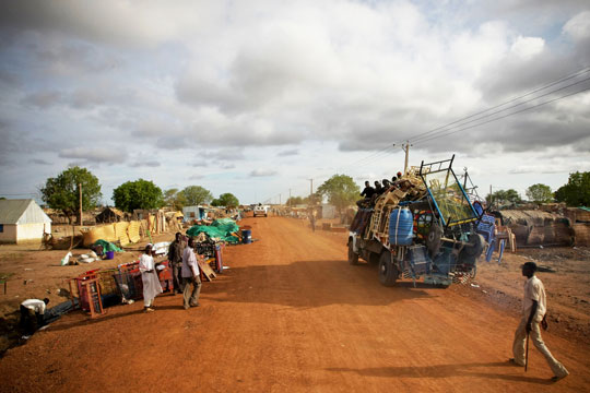 UN peacekeepers pass through streets lined with looted items awaiting collection in Abyei. UN Photo/Stuart Price/May 2011.